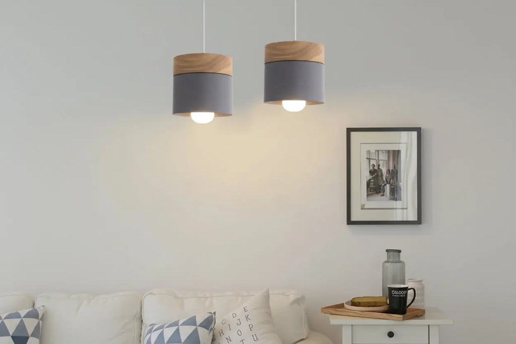Two pendant lights hanging above a sofa in a living room with a framed photo on the wall.